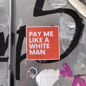 Red sticker that says "pay me like a white man" in red