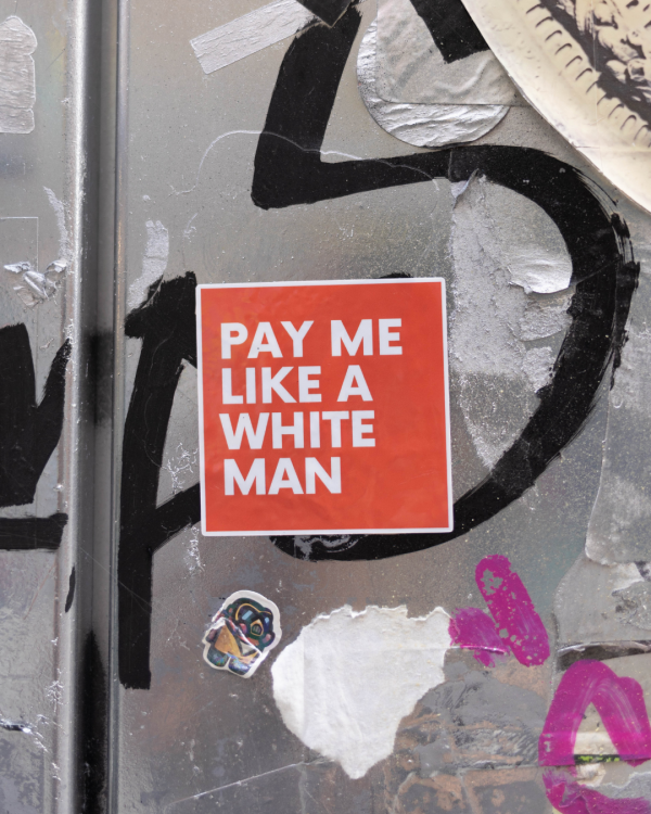 Red sticker that says "pay me like a white man" in red