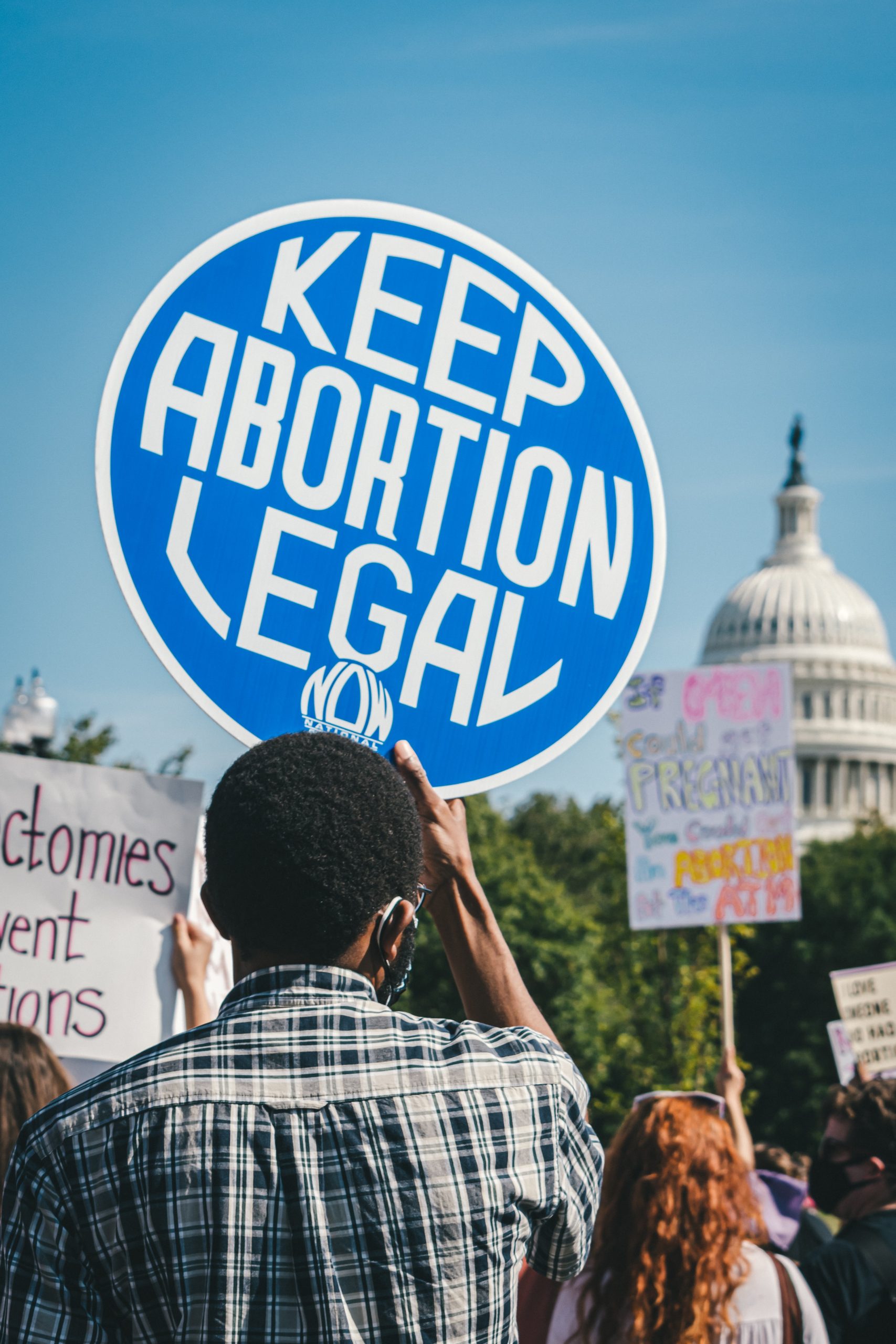 man holding protest sign that says keep abortion legal