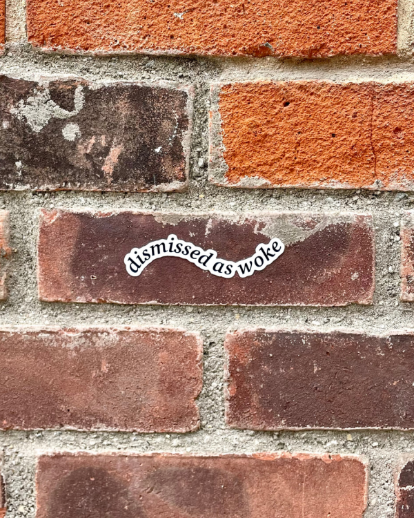 dismissed as woke sticker on brick wall