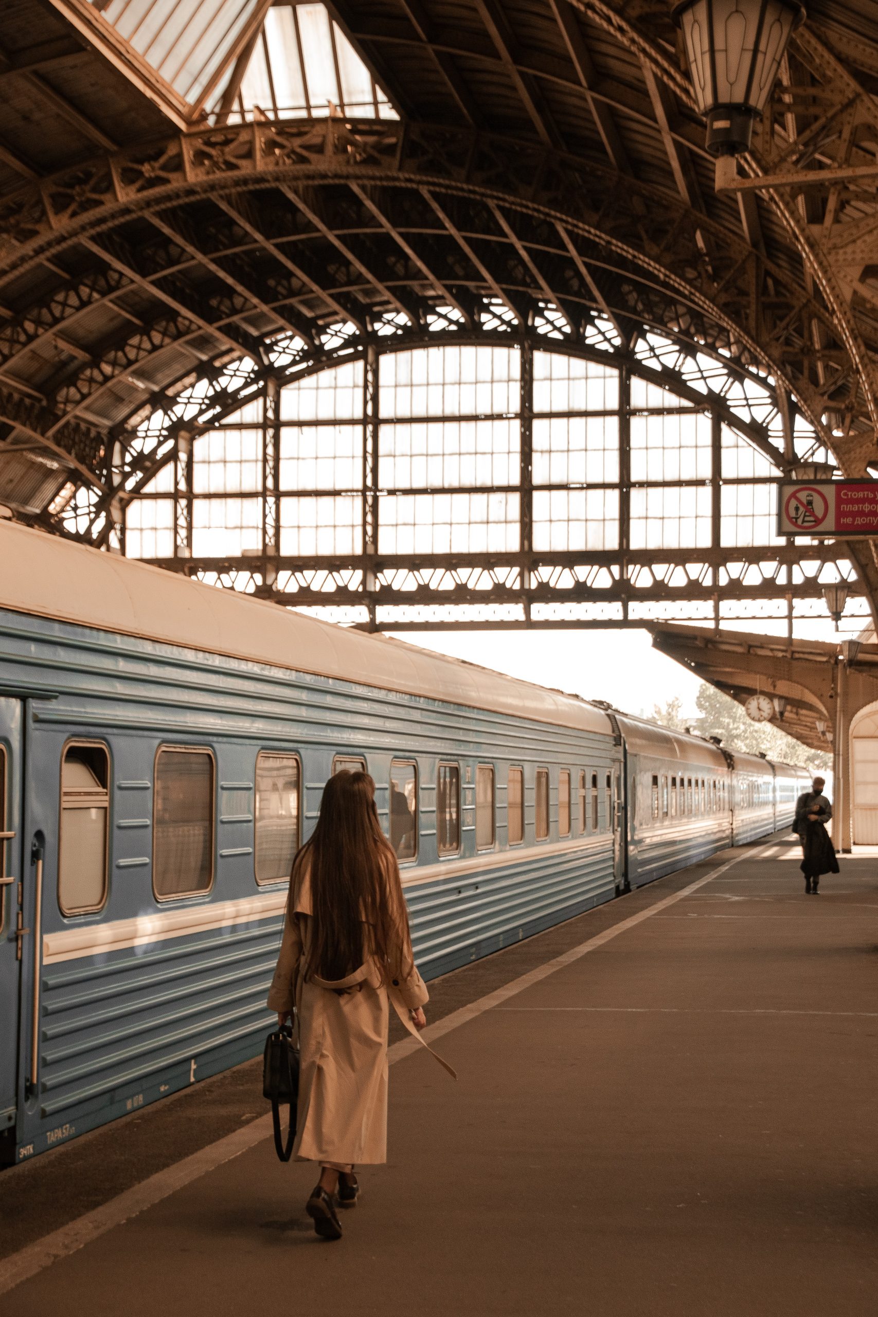 woman walking next to train in station in Russia